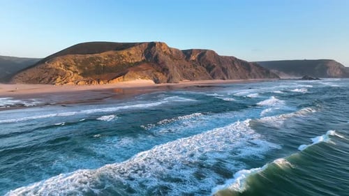 Cliff-lined beach with rolling surf waves