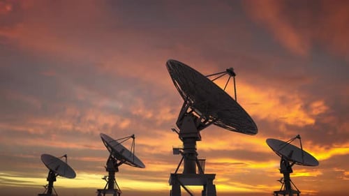 Communication Satellite Dishes Rotating Under Sunset Sky
