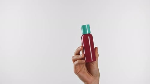 Hand Holding Red Bottle with Turquoise Cap