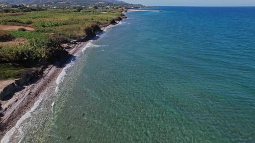 Coastal view of clear water and sandy beach during a sunny day in summer