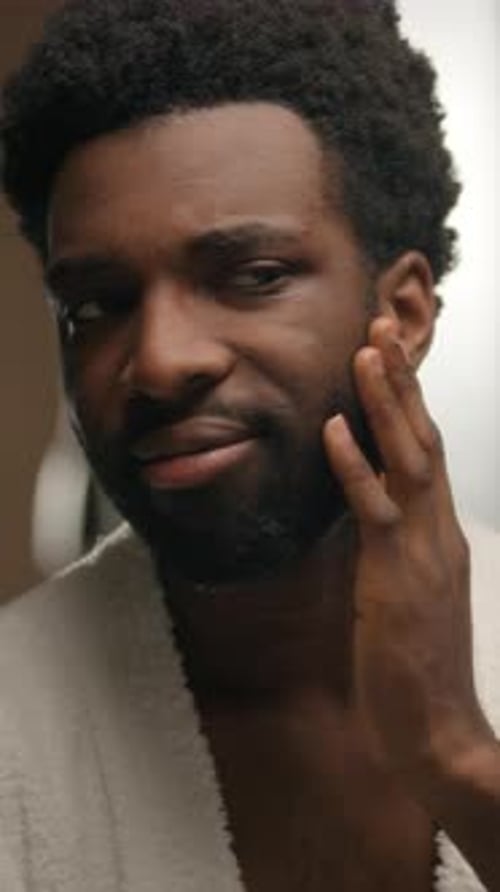 African American Man Looking at Mirror Reflection Hotel Bathroom Smiling Bearded Guy Shaving Beard
