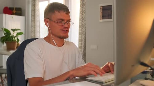 Young Adult Typing on Computer at Home
