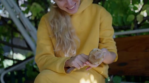 A Woman Cleaning Porcini Mushrooms in the Garden with a Knife Closeup