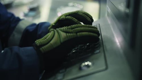 Worker Operating Industrial Control Panel with Gloves