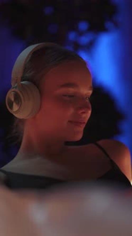 Vertical Video Cheerful Woman with Headphones Lies in the Sensory Deprivation Chamber Multicolored