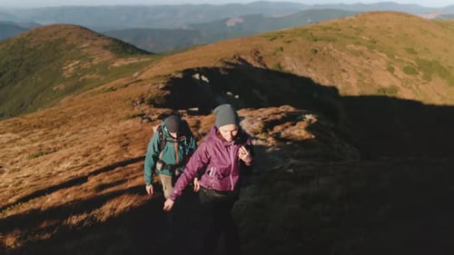 Couple Hiking Up Mountain Ridge Enjoying Scenic View of Carpathian Mountains
