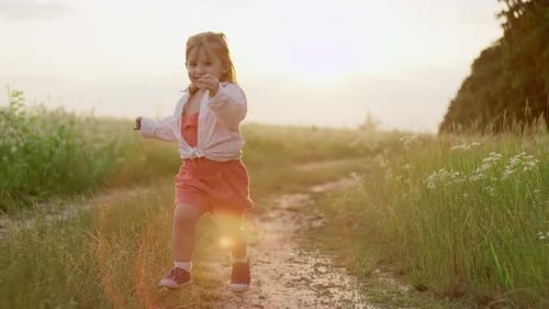 Slow Motion Video of a Girl in a Dress Running Across a Field at Sunset