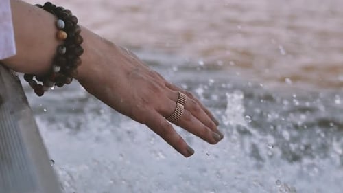 Woman hand touching Congo river water during holidays in boat and she's refreshing with Congo river.