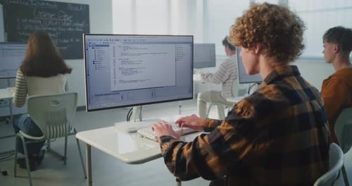 Estudiante concentrado escribe Código de Computadora Rápidamente en el Teclado