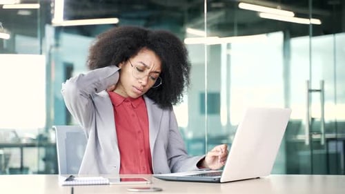 Woman Working at Computer in Office Rubs Neck