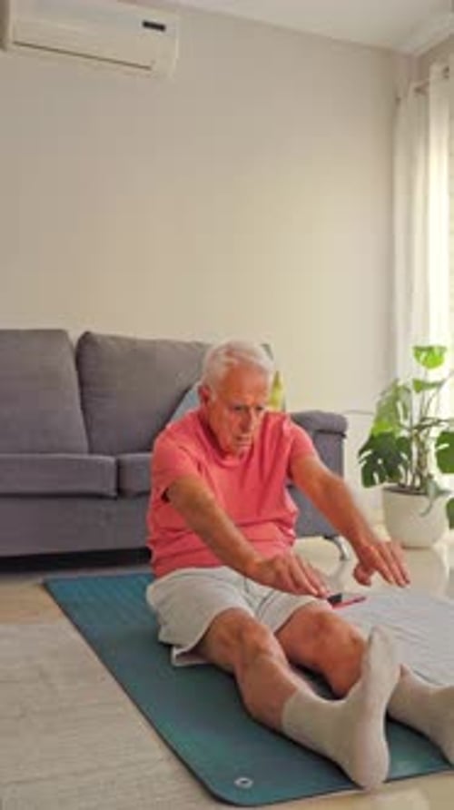 Senior Man Stretching on a Mat in Living Room