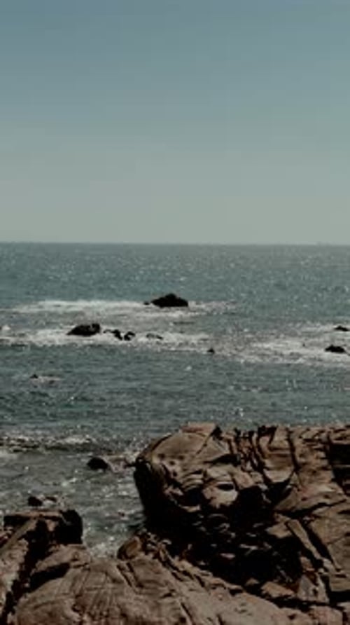 Ocean waves breaking over rocks with distant horizon