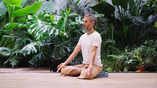Man Meditating Peacefully in a Lush Garden