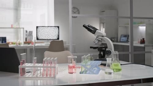 Microscope and Scientific Glassware with Colorful Liquids in Laboratory