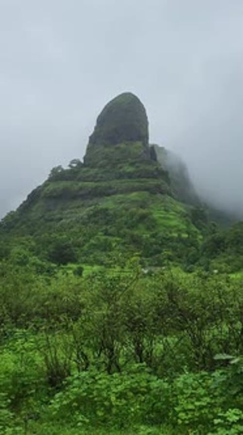 Pináculo do Forte Kurdugad durante o pico da monção coberto de neblina e nuvens, Mangaon, Maharashtra