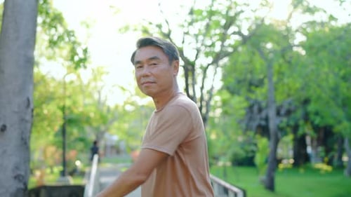Asian senior elderly man stretching body before exercise in the garden.