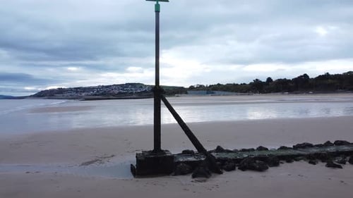 Coastal tide marker aerial view low slow rising above moody overcast low tide seaside beach