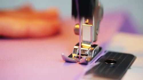 Sewing machine presser foot skillfully stitching fabric in a tailoring workshop