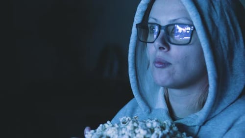Woman Watching Movie at Night Eating Popcorn