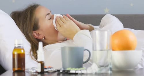 Woman in Bed with Cold or Flu Symptoms