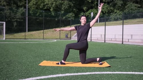 Woman Stretching Limbs on Yoga Mat Outdoors Daytime