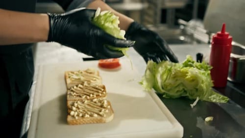 professional kitchen in a restaurant the chef lays out the ingredients for a club sandwich on toast
