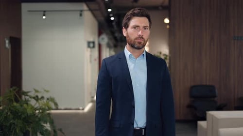 Portrait of Caucasian Businessman in Suit Standing at Office and Smiling