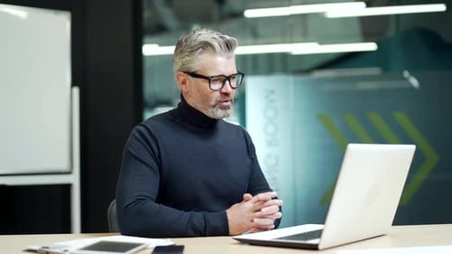 Mature Man Video Call at Modern Office Desk