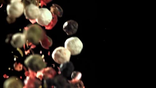 Falling Multi-Colored Peppercorns on Black Background