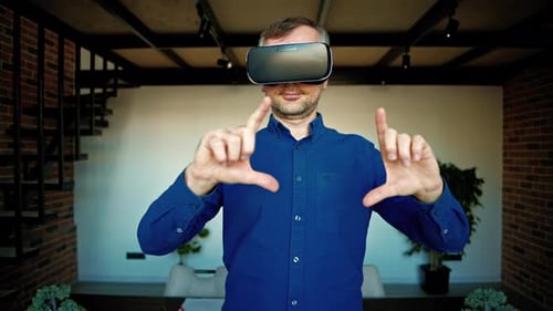 Man gesturing while using a Virtual Reality headset in an office
