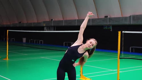 Sports Young Woman with Racket and Shuttlecock is Exercising Doing Warmup Before Playing in