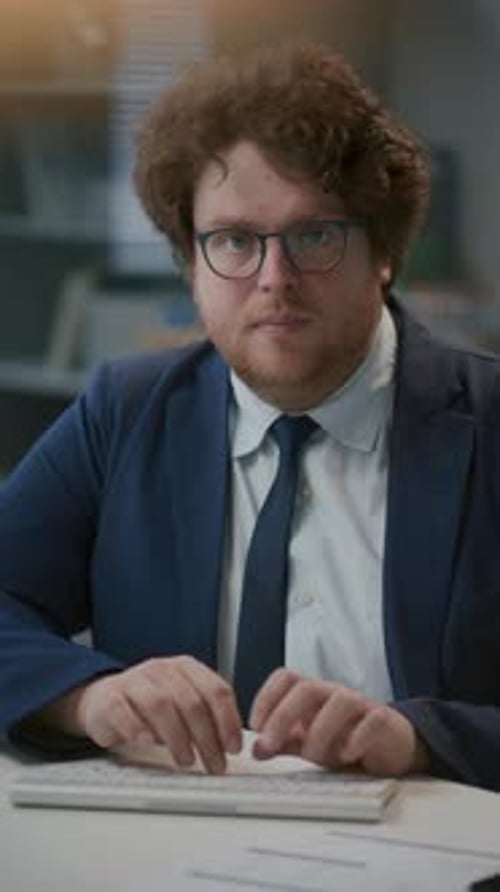 Portrait of Businessman Typing on Computer Keyboard at Office Desk