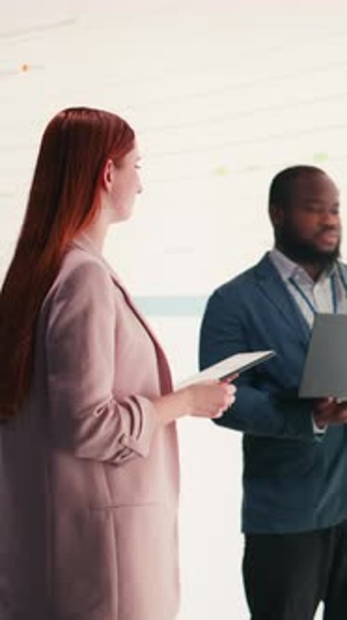 Vertical Video Businesspeople Use Laptop to Analyze Economic Data Graphs