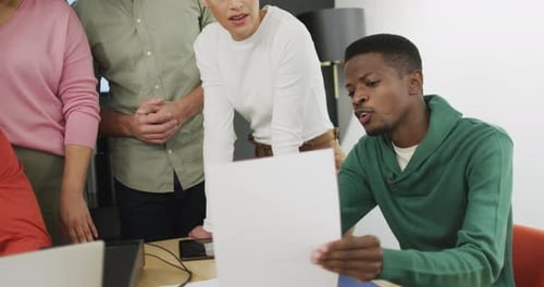 Happy diverse business people discussing work during meeting at office