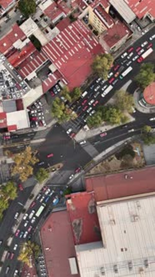 Slow motion aerial view of a bustling avenue with busy intersections and crosswalks, CDMX, vertical