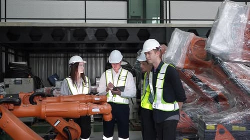 Ingenieure, die an der Entwicklung einer automatisierten Produktionslinie mit Roboterteilen arbeiten. Präzise Technik