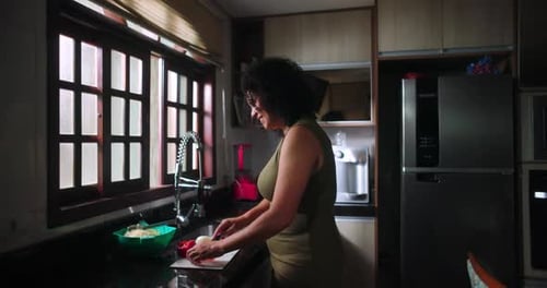 Woman Prepares Food in Kitchen at Home