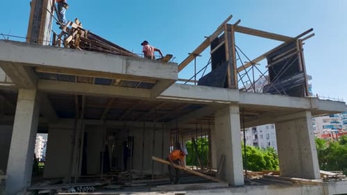 Luftbild: Belebte Baustelle mit Facharbeitern, die stetig Fortschritte machen