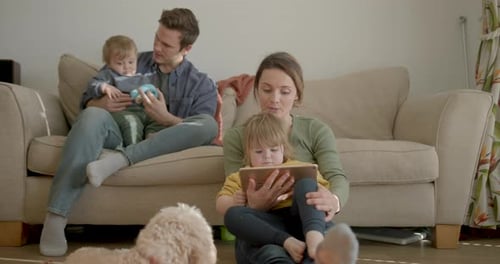 Family Relaxing Together in Living Room with Tablet