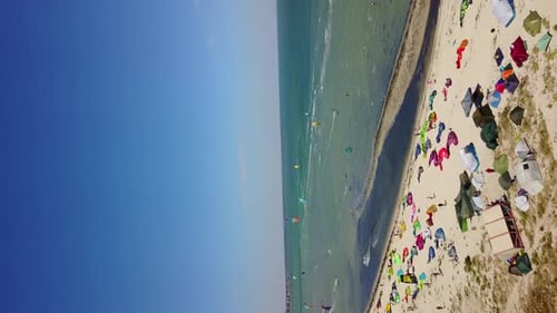 Aerial of Many Kiteboarders with Colorful Kites Flying Over the Blue Sea Lagoon Ride on Kiteboards