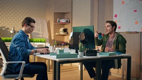 Inspired Designers Communicating Together at Office Guys Drinking Tea Working