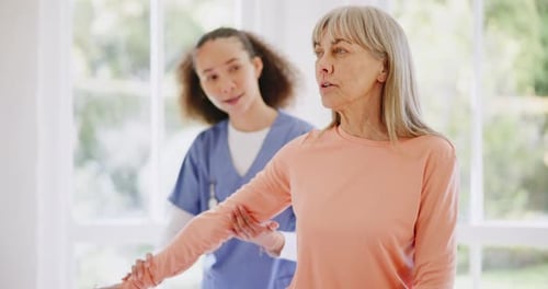 Mature Woman Doing Dumbbell Exercises with Therapist