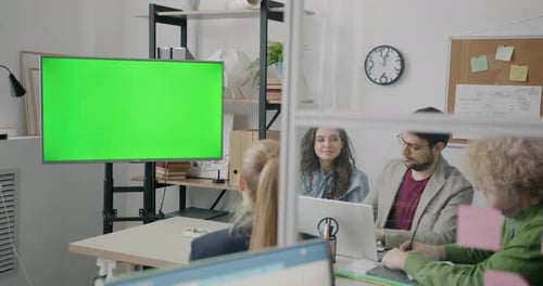 Group of Employees Looking at Green Chroma Key Screen and Talking During Business Meeting in Office