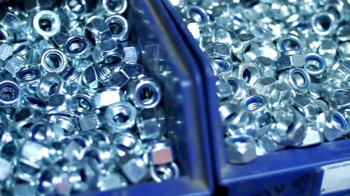 Des tas d'écrous en acier filetés brillants prêts à répondre aux besoins d'ingénierie industrielle dans les rayons des magasins