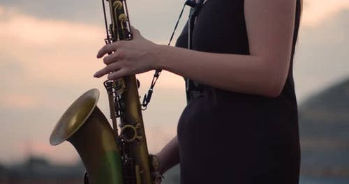 Musician Playing Saxophone at Sunset in City