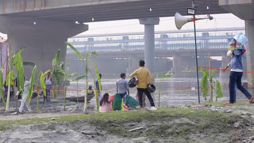 People Gather by River on Sunny Day