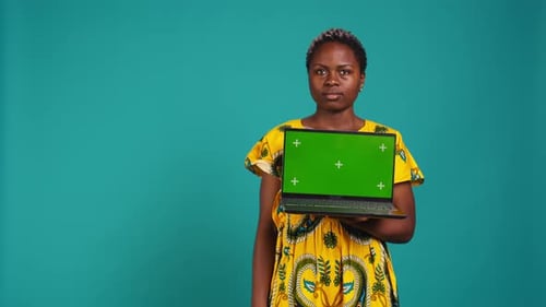 Optimistic Gorgeous Girl Holding a Pc with Isolated Green Screen
