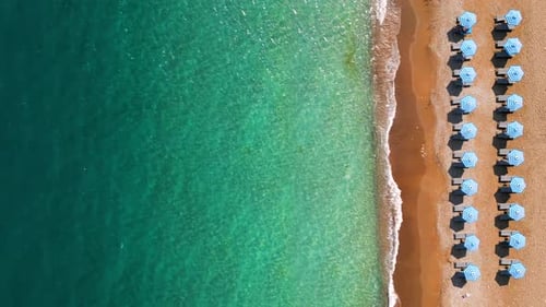 Topdown View of Sandy Beach with Sun Umbrellas and Turquoise Sea Water