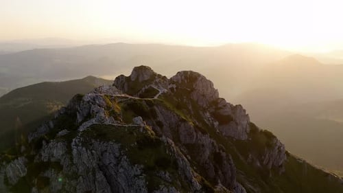Aerial Drone Orbit Shot Around a Majestic Mountain Peak with Sunlight