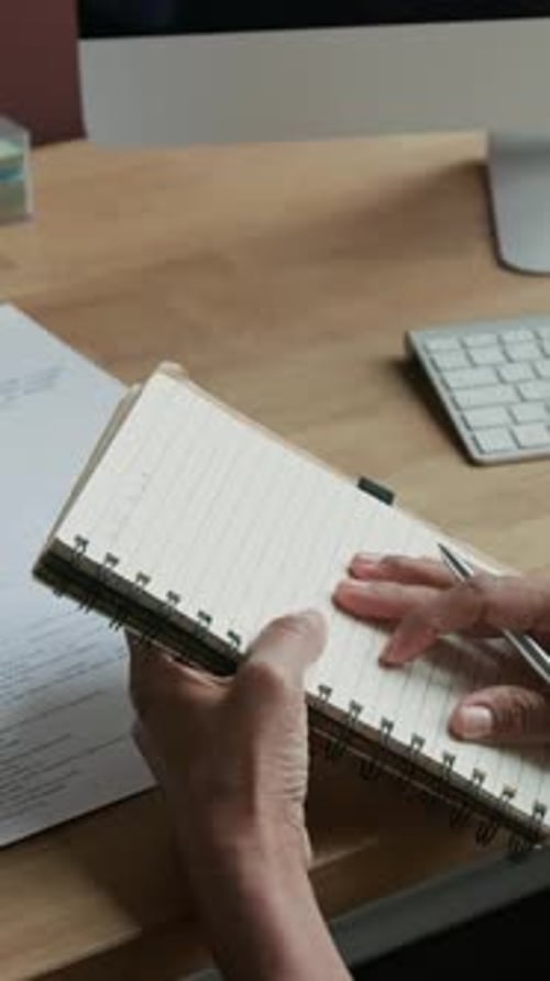 Hands Writing in Notebook at Office Desk